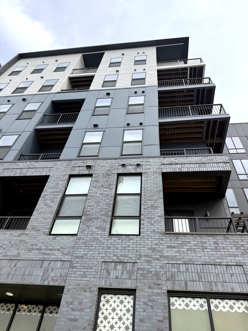 Looking up the facade of Rise on Meridian at tall windows and projecting balconies